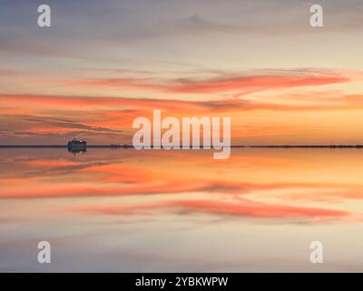 Le Sunshine Skyway offre Petersburg Florida Cruise Ship long Exposure. Un coucher de soleil serein se reflète vivement sur l'eau calme, le site historique. Banque D'Images