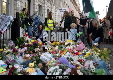 Le 19 octobre 2024, des personnes protestant contre le bombardement de Gaza laissent des fleurs et des peluches devant Downing Street Banque D'Images