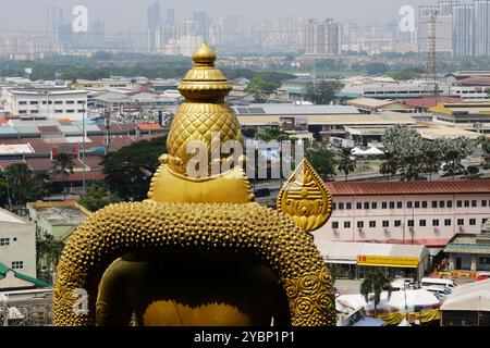 Kuala Lumpur, Malaisie - 7 août 2023 : la statue géante de Murugan, Dieu hindou de la guerre, est vue en arrière-plan par la ville de Kuala Lumpur, dans les grottes de Batu. Banque D'Images