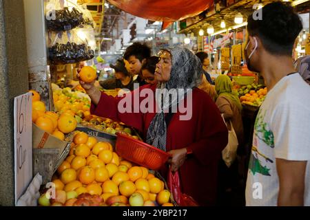 Kuala Lumpur, Malaisie - 3 août 2023 : les clients malaisiens achètent dans la section fruits et légumes du marché Chow Kit. Banque D'Images