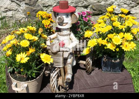 Les fleurs jaunes poussent dans des pots et jouet en bois dans le jardin Banque D'Images