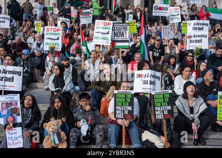 Londres, Royaume-Uni. 19 octobre 2024. Les manifestants sont assis dans les escaliers avec des pancartes pendant la manifestation. Des milliers de manifestants pro-palestiniens se sont rassemblés avec des fleurs et des jouets pour commémorer les victimes innocentes à Trafalgar Square à Londres, au Royaume-Uni. Il y a eu une petite contre-manifestation pro-israélienne également pendant la manifestation. Crédit : SOPA images Limited/Alamy Live News Banque D'Images