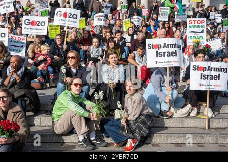 Londres, Royaume-Uni. 19 octobre 2024. Les manifestants sont assis dans les escaliers avec des pancartes pendant la manifestation. Des milliers de manifestants pro-palestiniens se sont rassemblés avec des fleurs et des jouets pour commémorer les victimes innocentes à Trafalgar Square à Londres, au Royaume-Uni. Il y a eu une petite contre-manifestation pro-israélienne également pendant la manifestation. (Photo de Krisztian Elek/SOPA images/SIPA USA) crédit : SIPA USA/Alamy Live News Banque D'Images