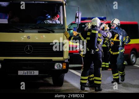 Jena, Allemagne. 20 octobre 2024. Dans un scénario d'embouteillage, les pompiers recherchent des personnes et les déplacent vers le tube voisin. Deux blessés ont été découverts dans un véhicule. Exercice majeur dans le tunnel du Jagdberg sur l'A4 entre les jonctions Bucha et Jena-Göschwitz dans la nuit du 19 au 20 octobre 2024. Environ 200 pompiers, membres de la protection civile et de la police des autoroutes participent à l'exercice. Crédit : Jacob Schröter/dpa/Alamy Live News Banque D'Images