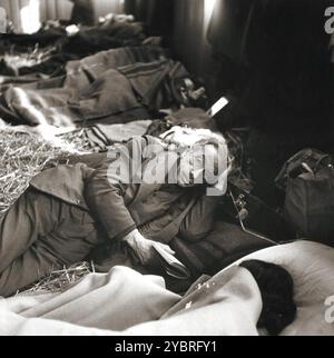 Un vieil homme juif sauvé de Theresienstadt repose sur un lit de paille dans le Hadwigschulhaus à Gall. Banque D'Images