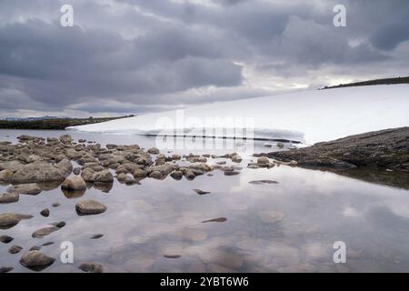 Ciel fortement nuageux se reflétant dans un lac sur le Norvégien plateau de montagne Aurlandsfjellet Banque D'Images