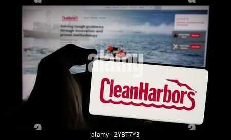 Personne tenant le téléphone portable avec le logo de la société de services américaine Clean Harbors Inc sur l'écran en face de la page Web. Concentrez-vous sur l'affichage du téléphone. Banque D'Images