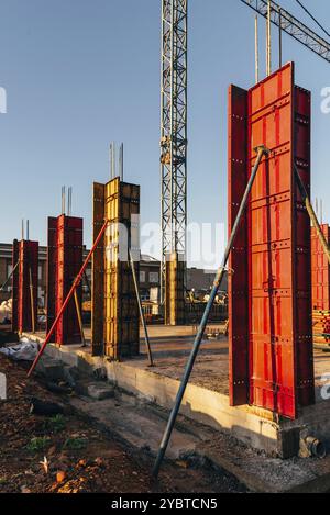 Chantier de construction avec coffrages en acier et barres de renfort pour piliers prêt pour le coulage du béton Banque D'Images