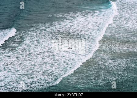 Vue aérienne des surfeurs surfant sur les vagues de la plage d'Antuerta à Ajo, Trasmiera, Cantabrie Banque D'Images