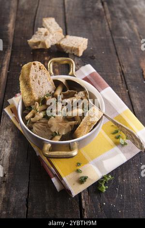 Marquage de présentation de la soupe aux champignons en pioppini sur table noire Banque D'Images