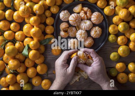 Présentation de petites mandarines pelées sur la vieille table en bois Banque D'Images