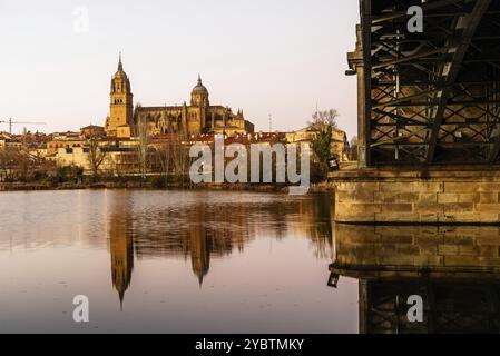 Vue panoramique de Salamanque avec la cathédrale et le pont de fer reflétés dans la rivière Tormes au coucher du soleil. Castilla Leon, Espagne, Europe Banque D'Images