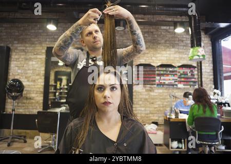 Femme se faisant couper les cheveux dans un salon de coiffure hipster Banque D'Images