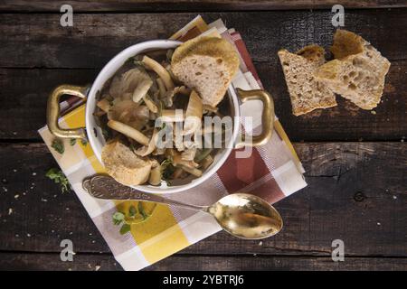 Marquage de présentation de la soupe aux champignons en pioppini sur table noire Banque D'Images