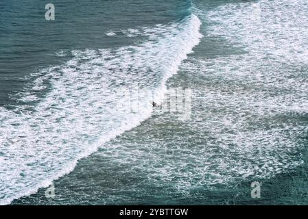 Vue aérienne des surfeurs surfant sur les vagues de la plage d'Antuerta à Ajo, Trasmiera, Cantabrie Banque D'Images