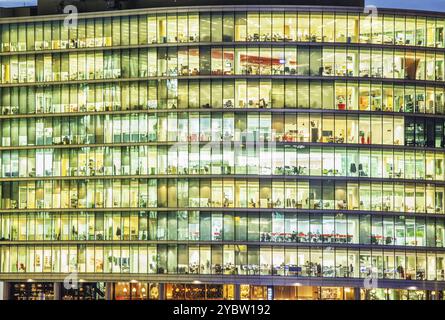 Bureau moderne la nuit, montrant l'activité quotidienne des employés de bureau Banque D'Images