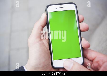 Point de vue d'un homme utilisant un smartphone avec un écran vert. Londres. Angleterre Banque D'Images