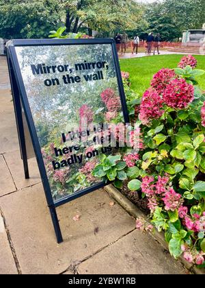 Un panneau en miroir lit miroir miroir sur la litière murale gauche ici reflète mal sur nous tous dans les terrains du cimetière de Saint Paul à St pauls Cathédrale Londres EC4M 8AD ; message anti litière parmi les parterres de fleurs prévues Banque D'Images