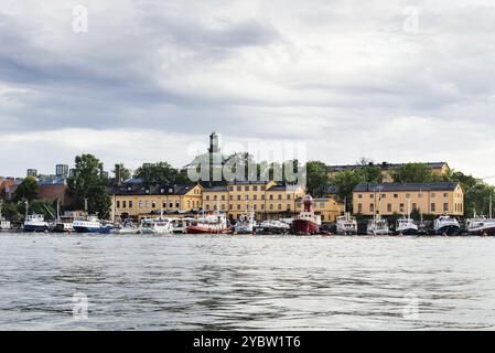 Stockholm, Suède, 9 août 2019 : front de mer de l'île de Skeppsholmen avec des navires, des maisons traditionnelles et le Musée Moderna, Europe Banque D'Images