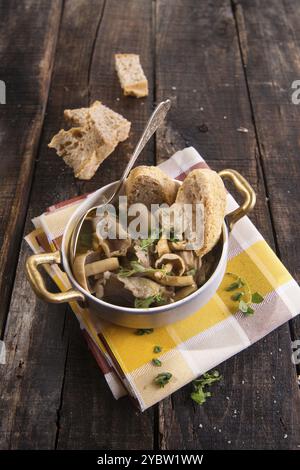 Marquage de présentation de la soupe aux champignons en pioppini sur table noire Banque D'Images