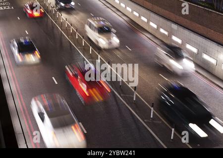 Vue en élévation du timelapse du trafic passant par un passage souterrain la nuit thèmes du trafic de transport aux heures de pointe Banque D'Images