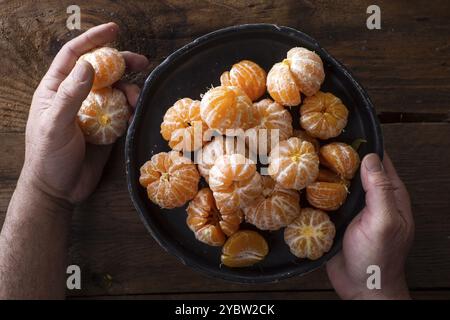 Présentation de petites mandarines pelées sur la vieille table en bois Banque D'Images