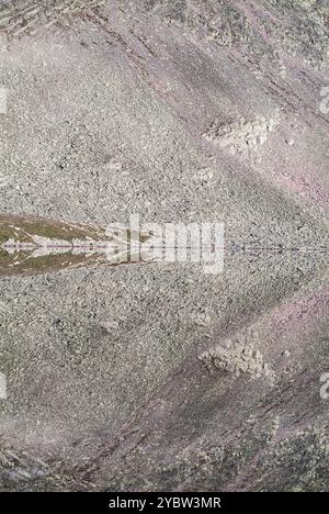 Un reflet parfaitement symétrique du terrain rocheux accidenté est capturé dans les eaux calmes du lac Mirror en Norvège, créant une vue presque surréaliste Banque D'Images