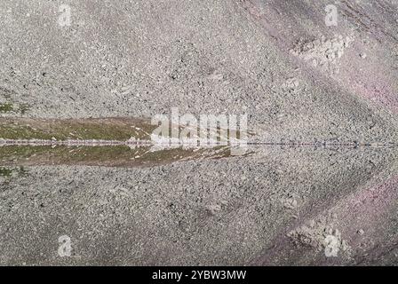 Un reflet parfaitement symétrique du terrain rocheux accidenté est capturé dans les eaux calmes du lac Mirror en Norvège, créant une vue presque surréaliste Banque D'Images