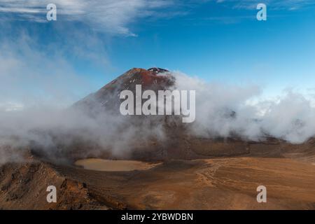 Vue du volcan Mont Ngauruhoe avec brouillard roulant sur la montagne et ciel cristallin (Tongariro Crossing, Île du Nord, Nouvelle-Zélande) Banque D'Images