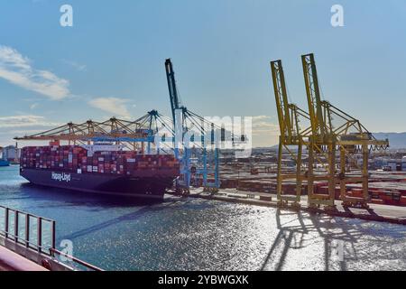 Barcelone. Espain -20 octobre 2024 : vue sur le port de Barcelone avec un cargo amarré et des grues déchargeant des conteneurs. Représente l'activité du port et Banque D'Images