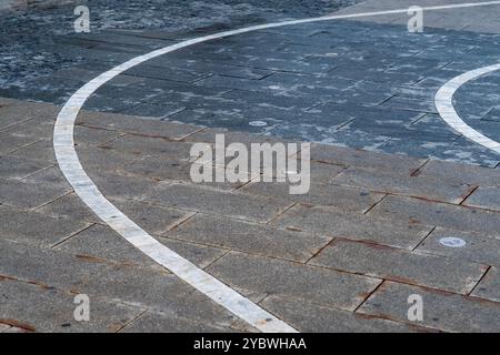 Lignes blanches courbes : zone de vélo marquée sur le sol du trottoir dans la rue urbaine Banque D'Images