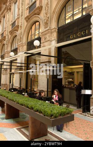 Les clients sont assis sous les chauffages extérieurs dans un petit café de la Galleria Vittorio Emanuele ll à Milan, en Italie. Banque D'Images