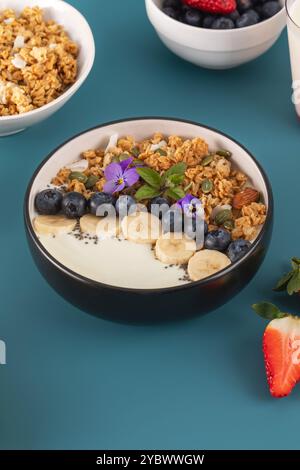 Un petit déjeuner sain et nutritif composé de yaourts grecs naturels, de granola et de baies fraîches. Banque D'Images