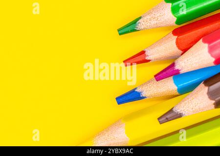 Cette image montre un gros plan de plusieurs crayons de couleur aiguisés avec des pointes pointant vers le coin supérieur droit du cadre. Banque D'Images