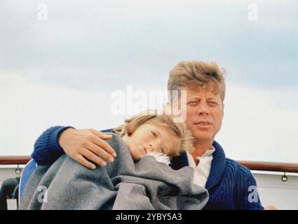 Le président américain John F. Kennedy assis avec son bras autour de sa fille, Caroline Kennedy, à bord du yacht présidentiel, « Honey Fitz », au large de Hyannis Port, Massachusetts, USA, Cecil Stoughton, photographies de la Maison Blanche, 25 août 1963 Banque D'Images