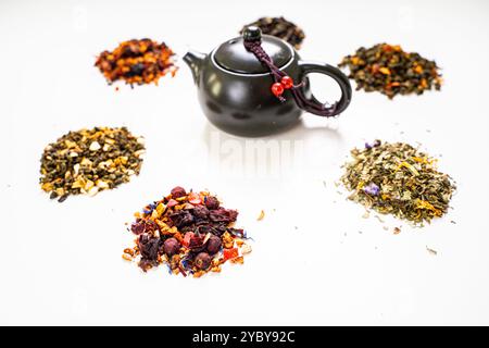 Assorti différents types de thé et une théière avec des tasses sur une table blanche. Photo de haute qualité Banque D'Images