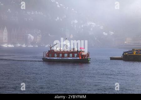 Le petit ferry portuaire Beffen traversant le port intérieur de Bergen, Norvège. Navigation au départ de Bryggen, la zone classée au patrimoine de l'UNESCO dans le port. Archi hanséatique Banque D'Images