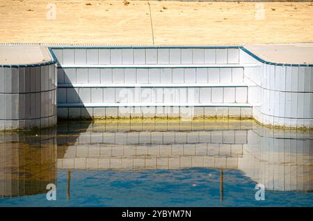 piscine sale avec de l'eau nuageuse en raison d'un manque d'entretien en hiver Banque D'Images