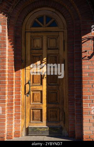 Une grande, étroite, vieille porte en bois. Entrée du bâtiment en briques. Photo de haute qualité Banque D'Images