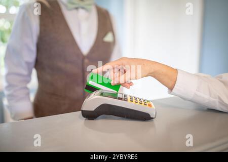 Client effectuant un paiement à un comptoir avec une carte en main Banque D'Images