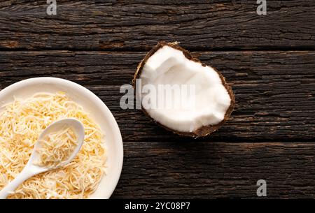 Cocos nucifera - flocons de noix de coco déshydratés avec du sucre dans le bol et la cuillère. Banque D'Images