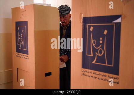 Duhok, Irak. 20 octobre 2024. Un électeur kurde prépare son bulletin de vote lors des élections législatives dans un bureau de vote de la ville de Duhok, dans la région autonome du Kurdistan irakien. Initialement prévu pour il y a deux ans, le vote a été reporté quatre fois en raison de différends entre les deux partis historiques de la région, le Parti démocratique du Kurdistan (PDK/PDK) et l'Union patriotique du Kurdistan (UPK). (Photo de Ismael Adnan/SOPA images/SIPA USA) crédit : SIPA USA/Alamy Live News Banque D'Images