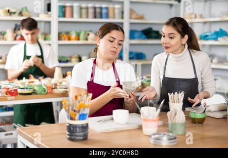 Deux jeunes femmes faisant de la poterie en atelier Banque D'Images