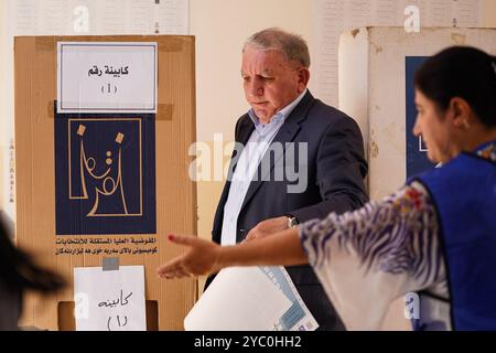 Duhok, Irak. 20 octobre 2024. Un électeur kurde prépare son bulletin de vote lors des élections législatives dans un bureau de vote de la ville de Duhok, dans la région autonome du Kurdistan irakien. Initialement prévu pour il y a deux ans, le vote a été reporté quatre fois en raison de différends entre les deux partis historiques de la région, le Parti démocratique du Kurdistan (PDK/PDK) et l'Union patriotique du Kurdistan (UPK). (Photo de Ismael Adnan/SOPA images/SIPA USA) crédit : SIPA USA/Alamy Live News Banque D'Images