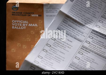 Fullerton, Californie, États-Unis - 20 octobre 2024 : la lumière de l'après-midi brille sur la table des documents électoraux et un vote blanc par bulletin postal pour Donald Trump Banque D'Images