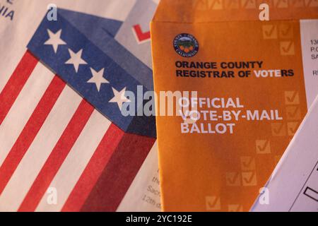 Fullerton, Californie, États-Unis - 20 octobre 2024 : la lumière de l'après-midi brille sur la table des documents électoraux et un vote par bulletin postal. Banque D'Images