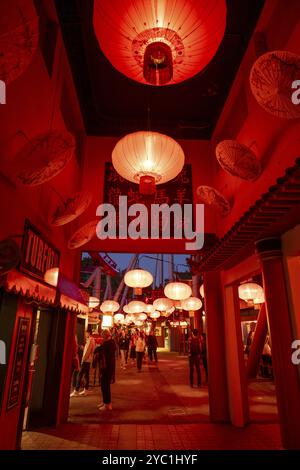 Visiteurs, quartier chinois avec des lanternes rouges et des panneaux traditionnels avec des personnages, illuminé la nuit, Tivoli Amusement and Recreation Park, C. Banque D'Images