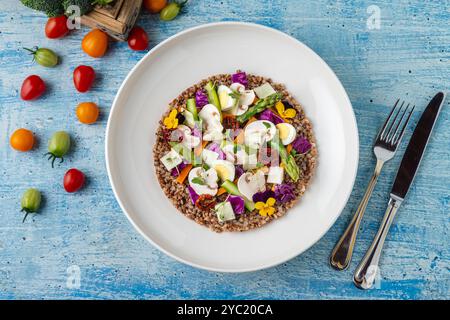 Salade de quinoa avec champignons, œufs et tomates séchées servies sur une assiette en porcelaine blanche Banque D'Images