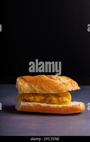 Un appétissant sandwich omelette exposé sur une élégante table en béton bleu, capturant l'essence de la cuisine moderne dans un cadre urbain Banque D'Images