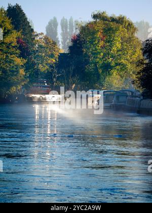 Une péniche amarrée par la Tamise à Abingdon, reflétant le soleil bas par un matin d'automne brumeux. Abingdon prétend être la plus ancienne ville d'Angleterre, et la Tamise traverse son cœur. Si vous faites une promenade en rivière ou du jogging la plupart des jours, vous pouvez souvent attraper des moments transitoires merveilleux et des effets de lumière comme celui-ci. Banque D'Images